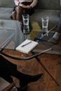 Close-up of a counseling session with two glasses of water and a notepad on a glass table.
